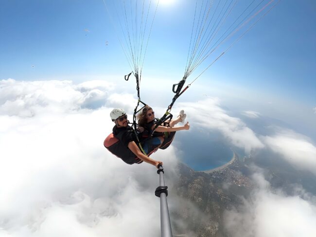 Fethiye’de Babadağ’dan tandem yamaç paraşütü yapan turistler, Ölüdeniz’in turkuaz denizi üzerinde muhteşem hava manzarasıyla