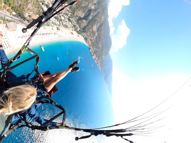 Paragliders taking off from Babadağ with Ölüdeniz lagoon view